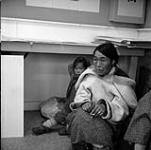 Lucy, a well known Inuit artist, with her child in the art centre at Cape Dorset August 1961.