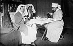 Infirmières militaires Thomson, Beers et Isaacson en train de prendre le thé dans les quartiers des infirmières à l'Hôpital général canadien no 2, à Le Tréport, France [document iconographique] janvier-mars 1917.