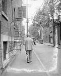 Man walking down an unidentified street ca. 1920s