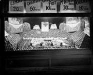 Display window of a produce store, showing stacked fruits and vegetables ca. 1920s