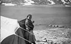 Inuit woman outside a tent ca. 1945-1946