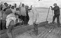 Inuits sur un quai, saluant de la main ca. 1945-1946