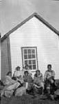 Inuit [Malaya Akulujuk (far left, looking over her shoulder), Nuqinngaq (seated under the window), Sulugaalik (second from right) and Qaunnaq (far right)] 1930