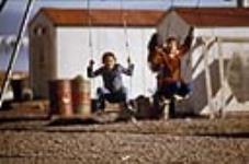Deux fillettes sur une balançoire vers 1974.