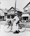 V.O.N. nurse standing with her bicycle, another means of transportation for the nurses c 1920