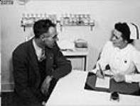 A company nurse interviews an employee at the E.B. Eddy Company in Hull, QC March 1946