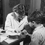 Une infirmière prélève un échantillon de sang d'un garçon du pensionnat indien de Port Alberni, C.-B. lors d'une étude médicale et dentaire menée par le ministère de la Santé et du Bien-être social en octobre 1948 Oct. 1948