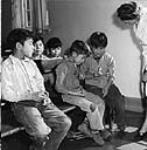 Une infirmièe du ministère de la santé et du Bien-être social contrôle le prélèvement des échantillons de salive des garçons du pensionnat indien; cette étude médicale et dentaire a été menée en octobre 1948 à Port Alberni, C.-B Oct. 1948