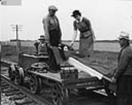 A patient is being transported to hospital from a rural section of Alberta by a railroad speeder under the supervision of a Provincial District Nurse Sept. 1947