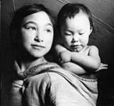 Adolescent Inuit girl and her sister, Taloyoak, Nunavut [Bella Lyall-Wilcox carrying her baby sister, Betty Lyall-Brewster, 1949] 1949.