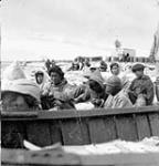 Group of Inuit men sitting and waiting to unload cargo [graphic material] 1951 ?