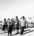 Group of Inuit men waiting to unload cargo [graphic material] 1951 ?