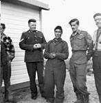 An unidentified Inuit man standing with four white males [graphic material] 1951 ?