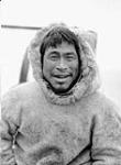 Unidentified Pingitkalik man wearing a fur parka and smiling [graphic material] 1933