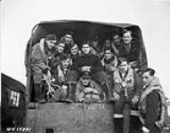 Les membres de l'équipage du 433e Escadron (Porcupine), ARC, se dirigent vers leur aéronef Handley Page Halifax B.III avant de décoller pour effectuer un raid sur Hagen, en Allemagne December 2, 1944