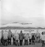 Inuit watching the arrival of the C.G.S. "C.D. Howe" at Pangnirtung July, 1951.