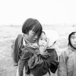 Inuk boy and an Inuk girl (Susan) carrying a baby Summer 1963