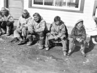 Inuit men and boys sitting outside a building 1944
