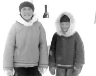 Young Inuit girl and boy posing outdoors and smiling at the photographer, Qamanittuaq, Nunavut, 1949 [the girl is Ruth Tulurialik] 1949.