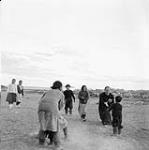 Inuk woman and children playing handball with priest 1948