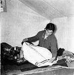 Inuk woman putting a zipper on a parka 1948