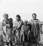 A group of Inuit women and children at Eskimo Point (Arviat) [1st on left, Arloonaaq, 3rd from left Aumow (could also be Aumauk), 4th Anita Iblauk, 5th Theresa Angmak] 1948