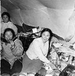 Two Inuit women and a girl inside a tupiq (skin tent) at Repulse Bay (Naujaat/Aivilik) 1948
