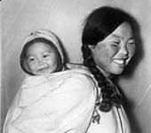 Inuk mother carrying a child in her amauti (parka) at Repulse Bay (Naujaat/Aivilik) 1948
