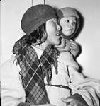 Inuk woman carrying her child in an amauti (parka) at Chesterfield Inlet (Igluligaarjuk) 1950