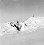 Two Inuit children outside an igloo 1950