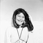 Inuk woman with a child in her amauti (parka) at Chesterfield Inlet (Igluligaarjuk) 1950