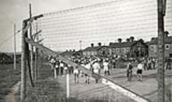[Prisoners of war walking inside wired fences of Red Rock Internment Camp, Ontario (Camp R)] [ca. 1940-1941].