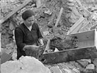 [Woman sorting through ruins] n.d.