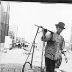 [Un homme chinois transportant un joug avec un panier]. 1897.
