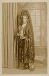 Portrait of Madge Macbeth wearing a Spanish costume, petal dress and interlocking pearls (pose 3) 1930s.