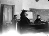 Unidentified woman probably teaching 2 unidentified young girls in a classroom 1896-1897