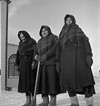 Three Cree women outdoors in winter clothing at Moose Factory, Ontario [Emily Wesley is in the centre and Jenshca Jan (Jane Sutherland) is on the right] January, 1946.