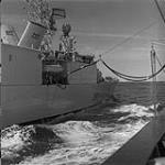 [HMCS IROQUOIS (DDG-280) alongside a replenishment vessel, performing a replenishment at sea (RAS)] 1972-1989.