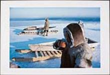 Two Igloolik hunters have tea and wait by their qamuti for seals. Floe edge, Igloolik, 1977 1977.