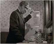[Scène du film « Red » de Gilles Carle] - Gratien Gélinas en personnage (tenant un objet dans les airs) [1970].