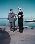 Maj.-Gen. E.L.M. Burns, UNEF commander, speaking with Cmdr. F.C. Frewer, HMCS MAGNIFICENT's Executive Officer, On Flight Deck of HMCS MAGNIFICENT 14-Jan-57