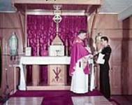 Roman Catholic Chaplain L. Kingston celebrating Holy Mass in Stella Maris chapel - HMCS STADACONA 1957