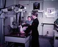 X-ray technician Geale taking an X-Ray of T. Baker's broken leg 16-JUL-57
