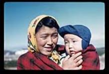 [Young Inuk woman, Annie Jonas, holding a little boy, Joseph Jonas, Kuujjuaq, Quebec] Young woman holding a little boy, Kuujjuaq, Quebec [between July 13-August 9, 1960]