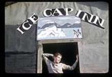 Barbara Hinds standing in the doorway of Ice Cap Inn [between June 17-October 31, 1960]