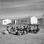 [Children sitting outside with their instructor] [between 1956-1960]