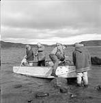 [Four men getting into a boat] [between 1956-1960]
