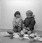 [Two Brownies, Martha (left) and Jo (right) pressing wildflowers, Iqaluit Nunavut] [between 1956-1960]