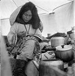 [Napatchie Pootoogook sewing a belt inside a tent, Kinngait, Nunavut] [between 1956-1960]