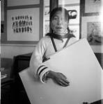 [Sheouak Petaulassie holding a canvas at West Baffin Co-operative, Kinngait, Nunavut] [between 1956-1960]